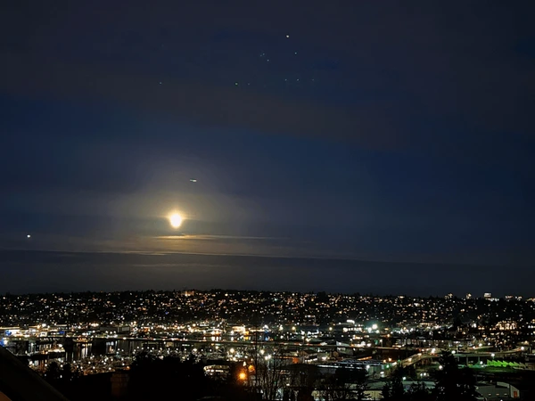 A calm evening cityscape with warm amber light and a quiet dusk sky
